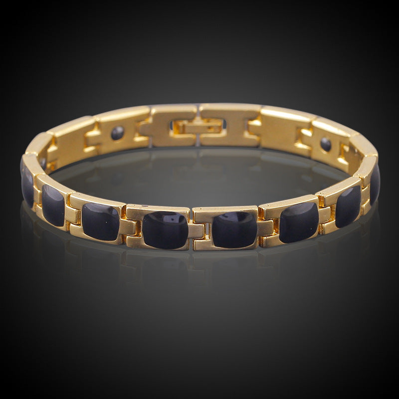 Gold bracelet with black stones on a dark background