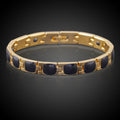 Gold bracelet with black stones on a dark background