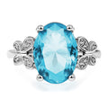 Ring with a blue gemstone and silver floral accents on a white background