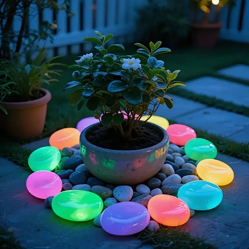 Glowing colorful stones around a potted plant on a patio