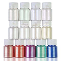 Set of small bottles with metallic powders in various colors on a white background