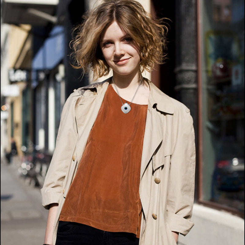 Woman wearing a beige trench coat over a rust-colored top on a city street.