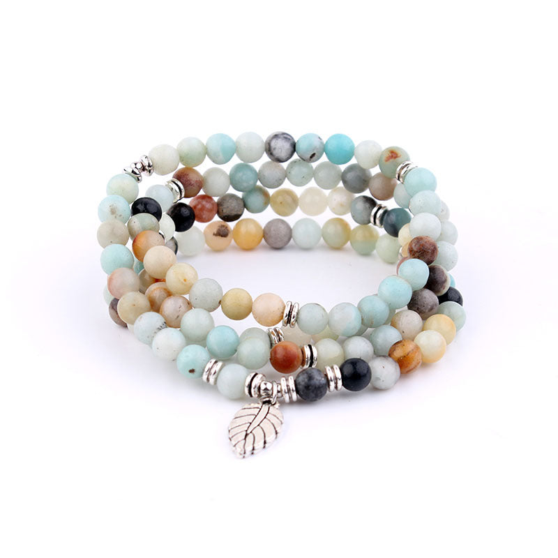 Multicolored beaded bracelet with a silver charm on a white background