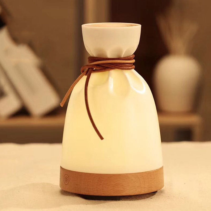Ceramic vase with wooden base and brown string on a neutral background