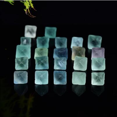 Set of colorful crystal cubes on a dark reflective surface