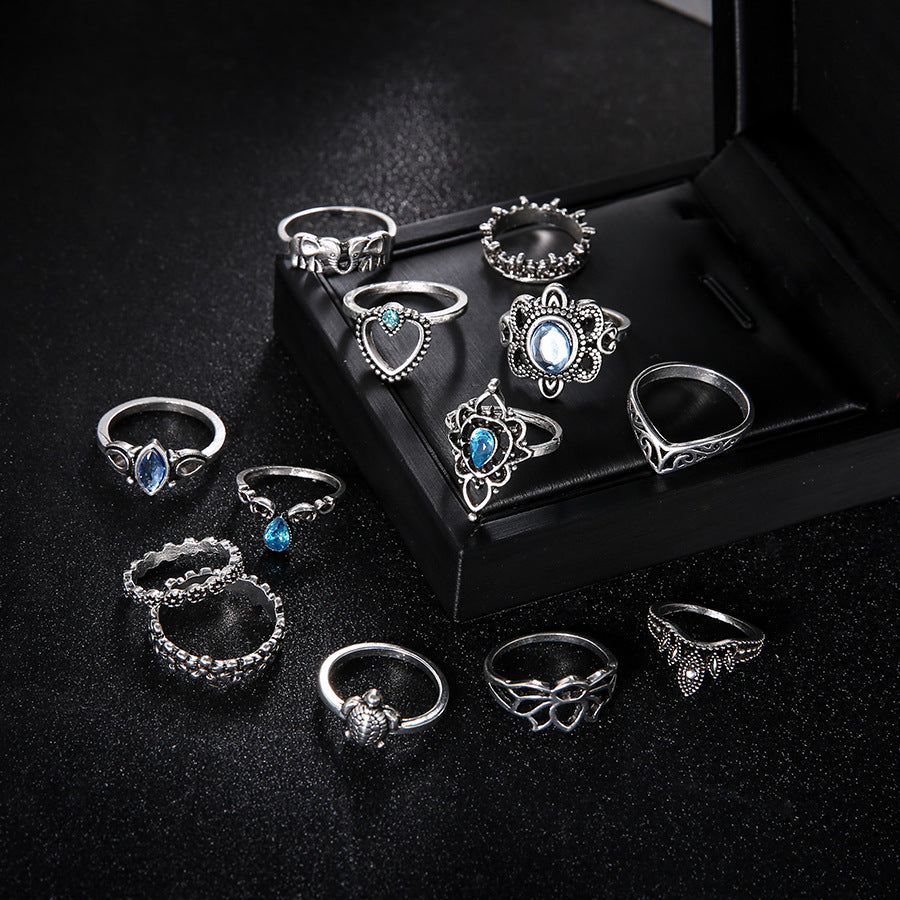 Set of silver rings with gemstones on a black surface