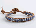 Bracelet with blue beads and brown leather strap on a white background