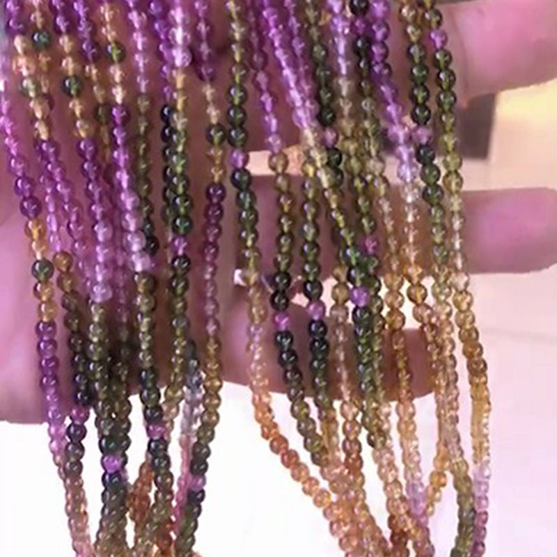 Close-up of multiple strands of multicolored beads held together.