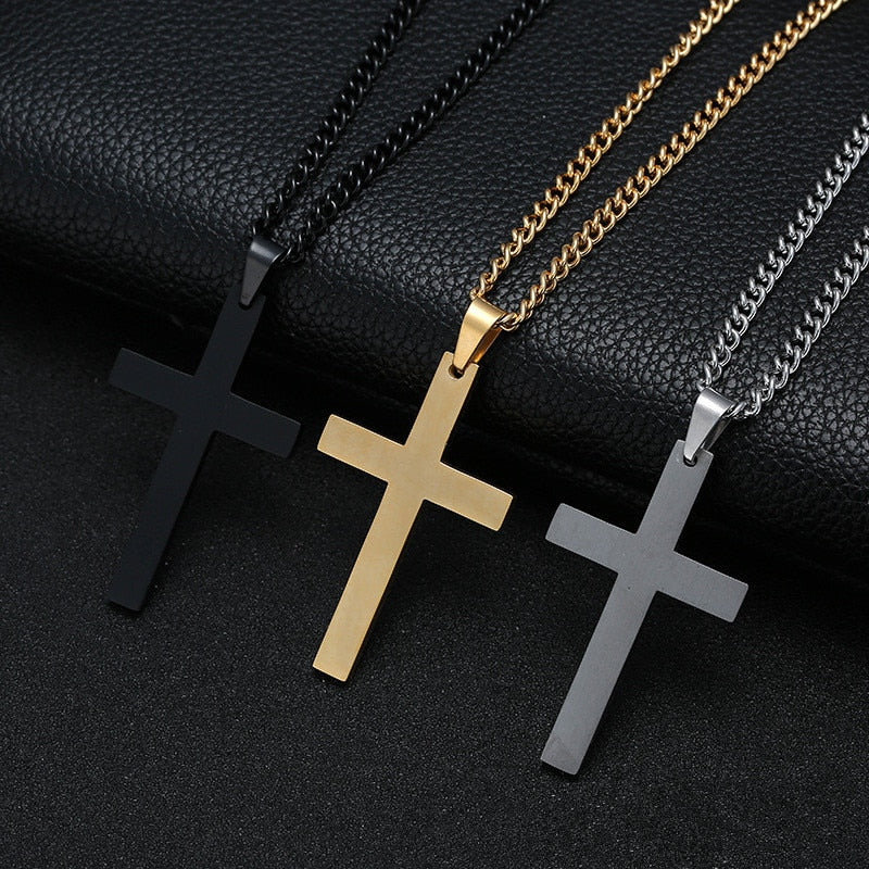 Three cross necklaces in black, gold, and silver on a dark textured background