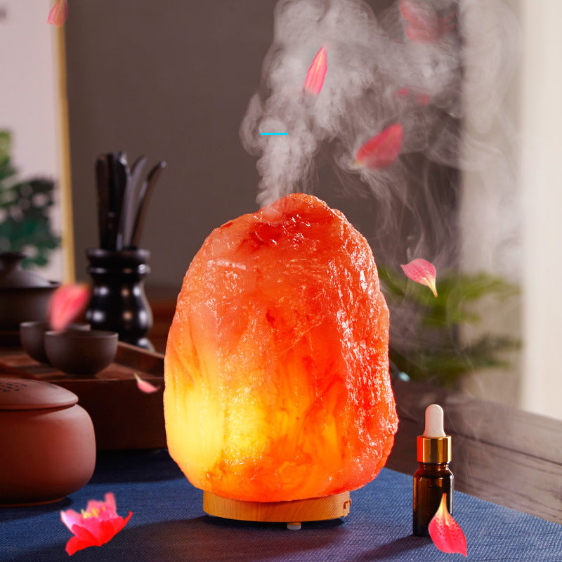 Himalayan salt lamp emitting steam with a dropper bottle on a table.