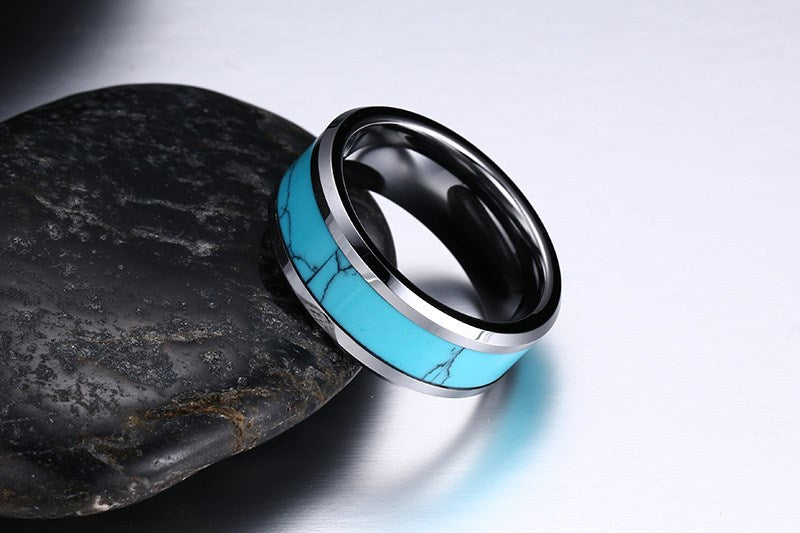 Turquoise and black ring on a dark stone surface