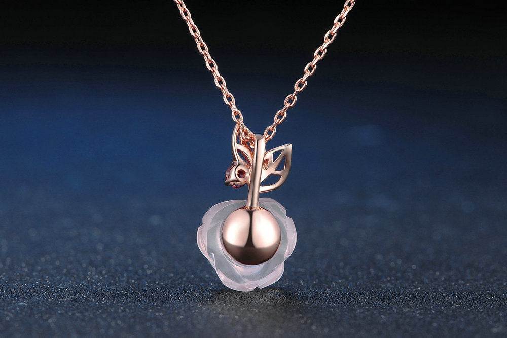 Rose gold necklace with a pendant on a dark background
