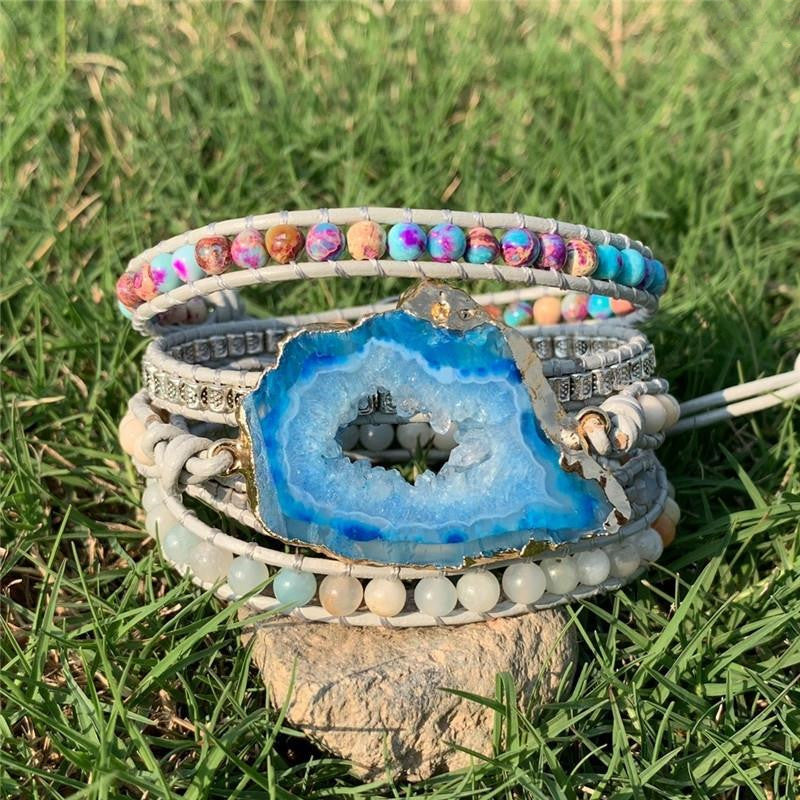 Multicolored beaded bracelet with a blue geode stone on a grassy background