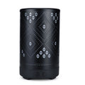 Black cylindrical lantern with geometric pattern on a white background