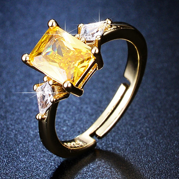 Gold ring with a yellow gemstone on a dark blue background