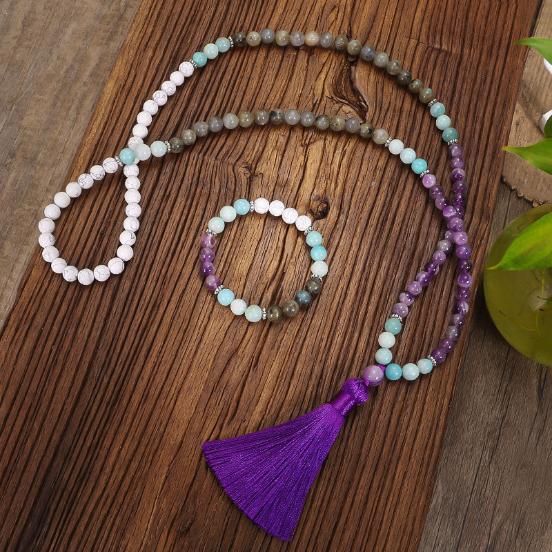 Beaded necklace with a purple tassel on a wooden surface