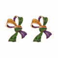 Bow-shaped earrings with green, purple, and gold colors on a white background
