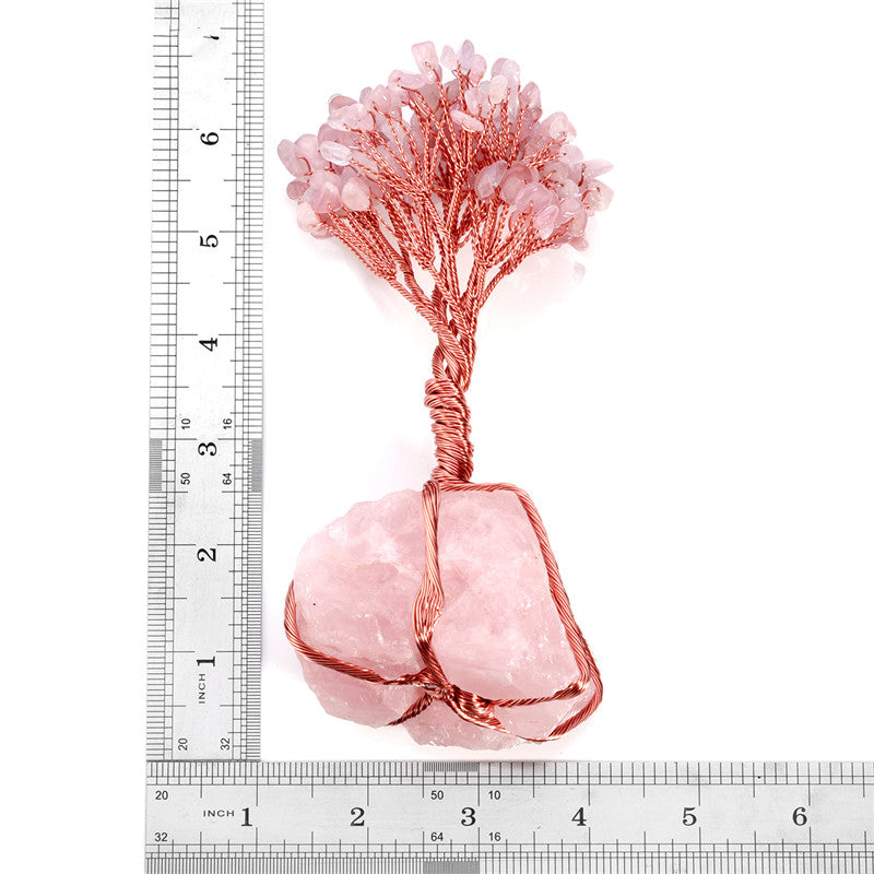 Decorative pink rock with copper wire and a ruler for scale on a white background