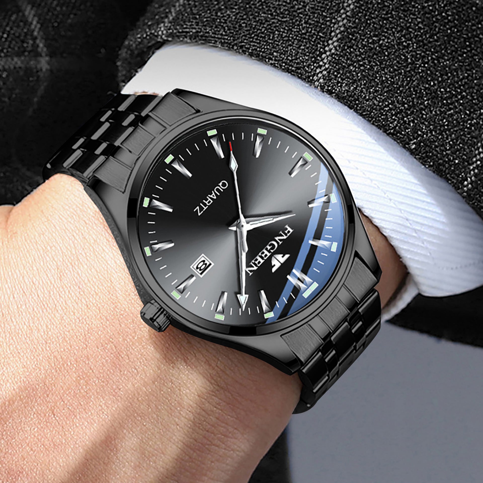 Black wristwatch with a detailed face on a person's wrist, wearing a checkered shirt.