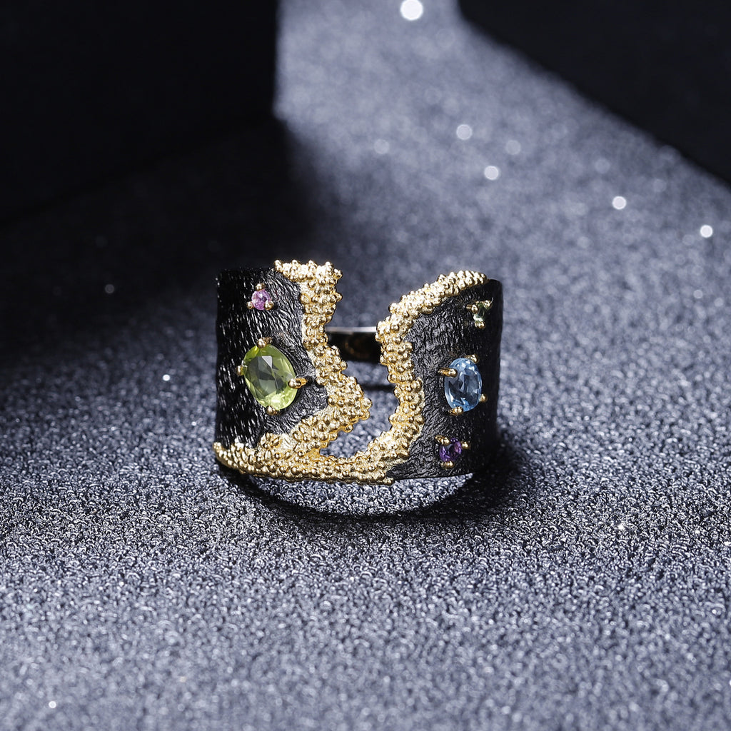 Decorative ring with gemstones on a textured black surface