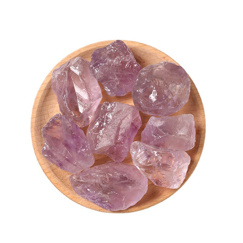 Amethyst crystals on a wooden plate with a white background