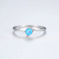 Silver ring with a blue gemstone on a light gray background