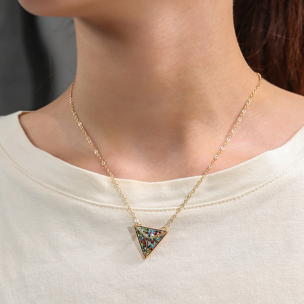 Necklace with a triangle pendant worn by a person on a plain background