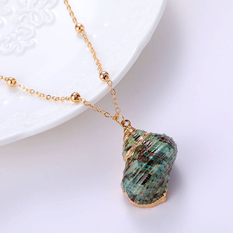 Necklace with a green shell pendant on a white background