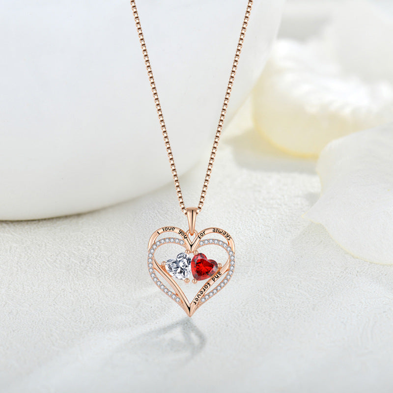 Heart-shaped necklace with red heart pendant on a white background