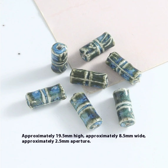 Set of cylindrical ceramic beads with blue and green stripes on a white background.