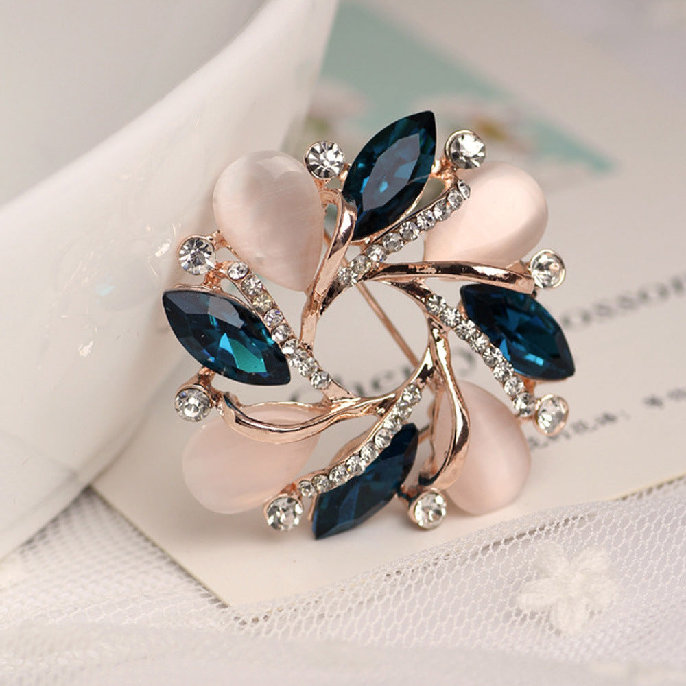 Decorative brooch with blue gemstones and rose gold accents on a light background