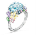Ring with a large blue gemstone and smaller pastel-colored stones on a white background