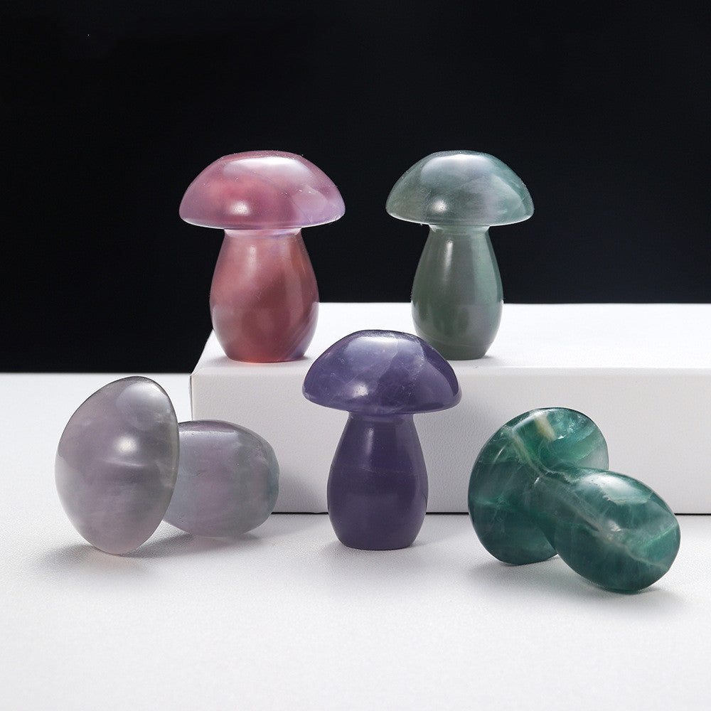 Colorful crystal mushroom-shaped objects on a white surface with a black background