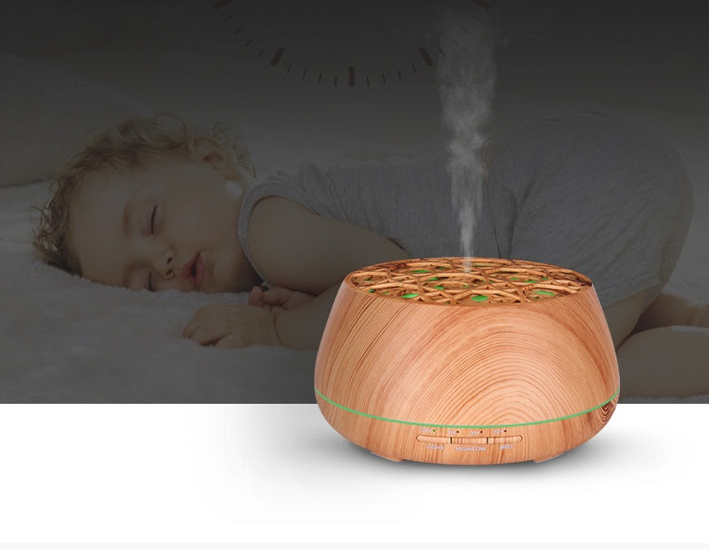 Wooden diffuser emitting steam with a child sleeping in the background