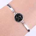 Silver bracelet with a black druzy stone on a wrist against a white background