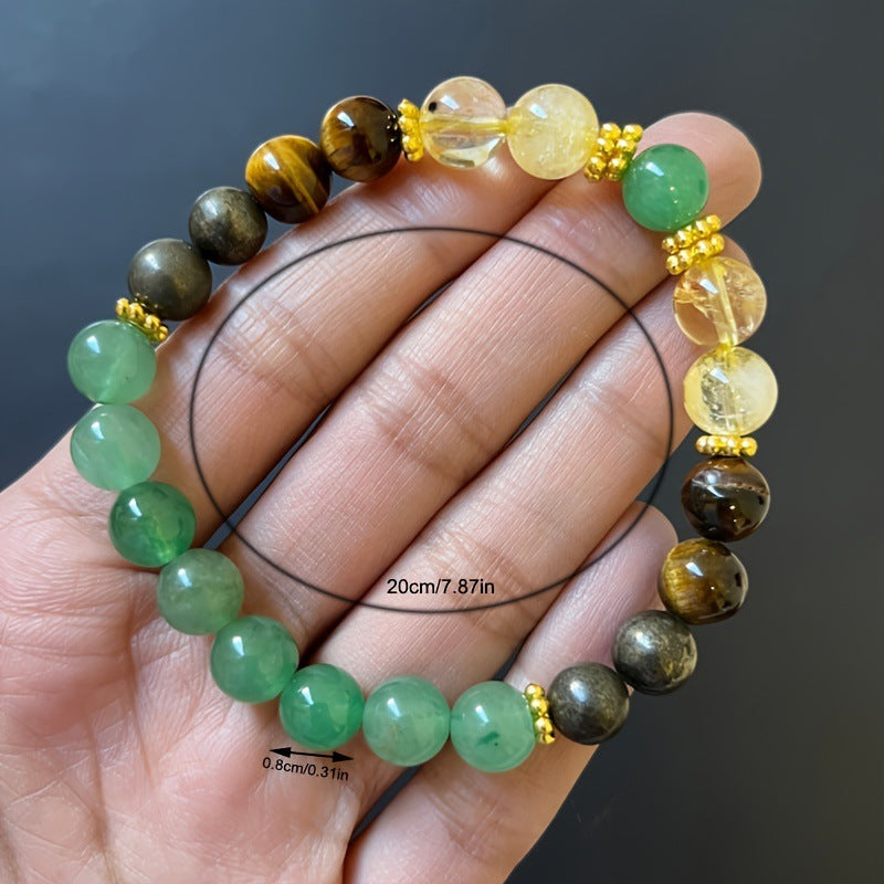 Beaded bracelet with green, brown, and yellow beads on a hand against a dark background