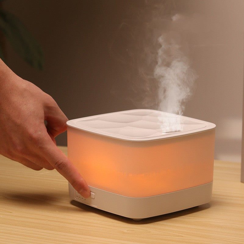 Hand interacting with a square humidifier emitting steam on a wooden surface.