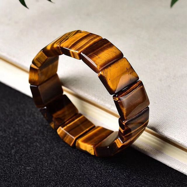 Wooden bracelet with a striped pattern on a textured surface