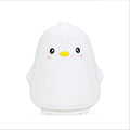 Cute penguin-shaped night light on a white background
