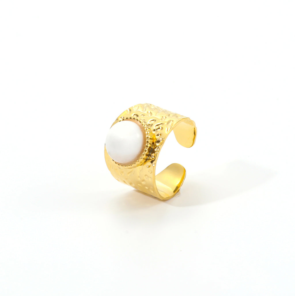 Gold ring with a white stone on a white background