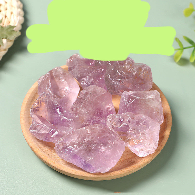 Amethyst crystals on a wooden plate with a green leafy background