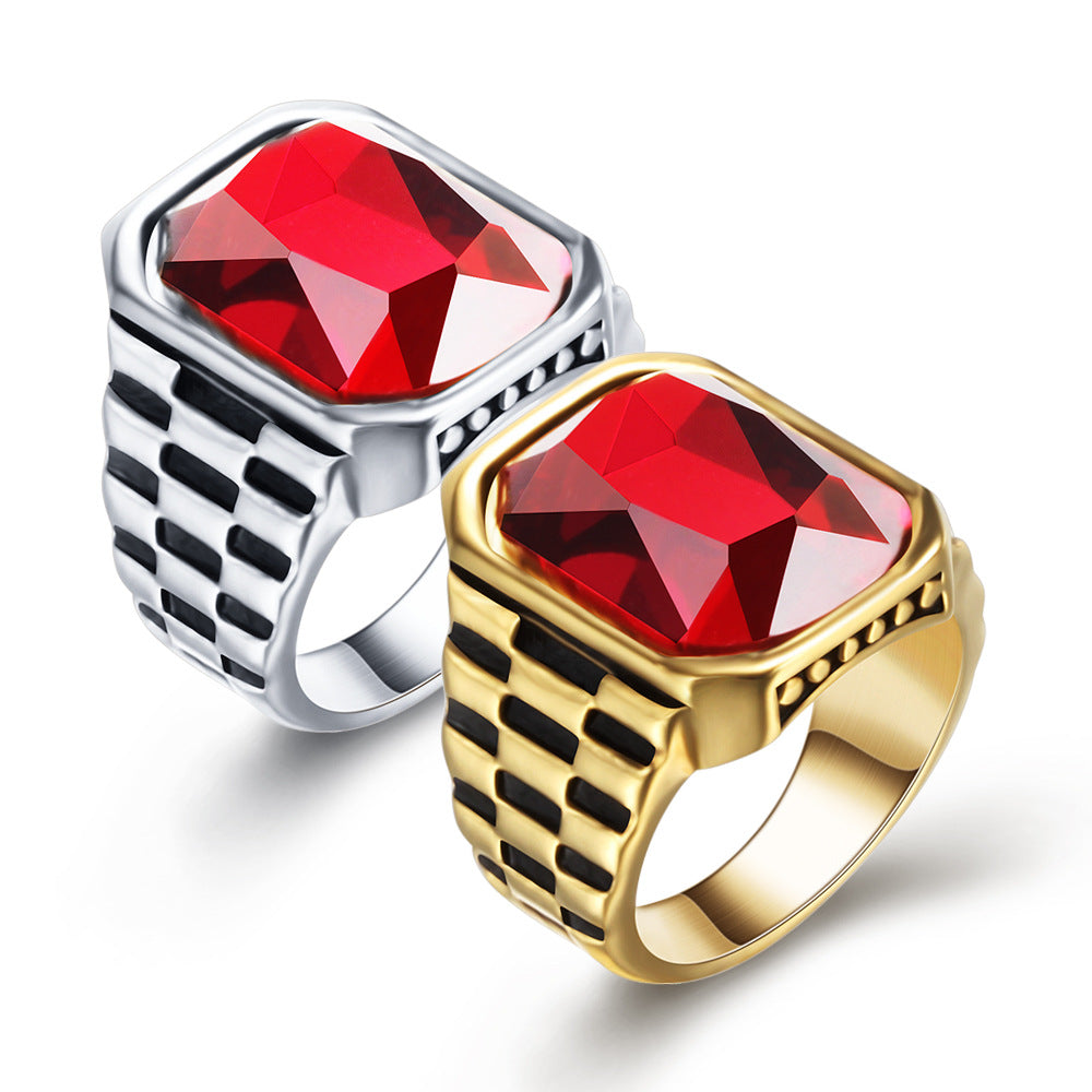 Two rings, one silver and one gold, with red gemstones on a white background.