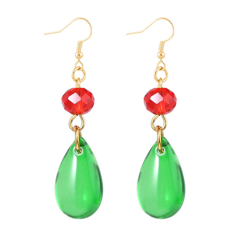 Pair of earrings with green teardrop beads and red circular beads on gold hooks against a white background.
