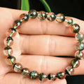 Green beaded bracelet on a hand with a blurred background