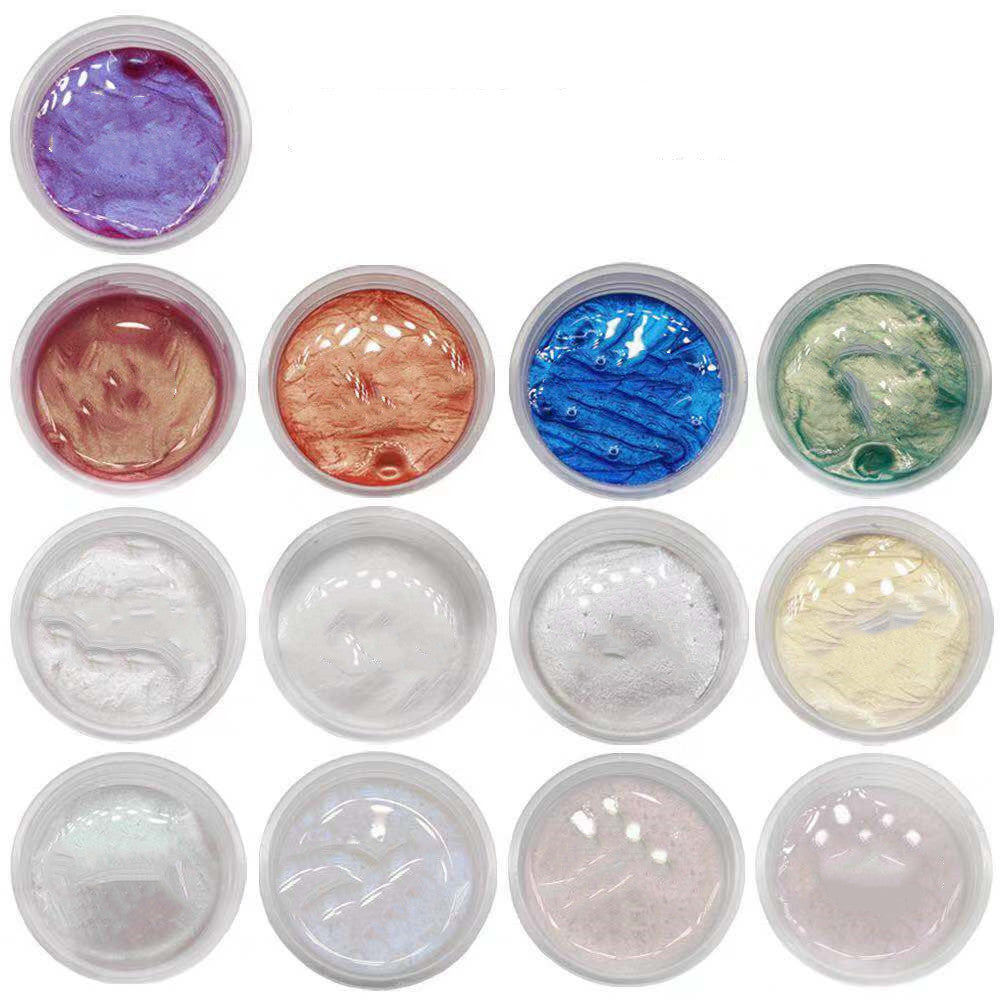 Set of 12 small containers with colorful slime-like substances on a white background