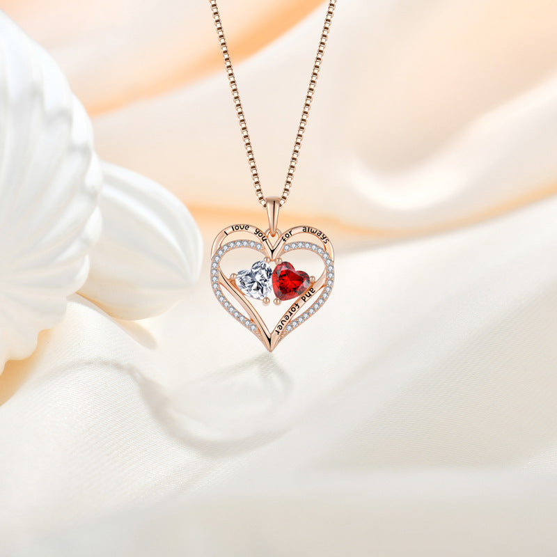 Heart-shaped necklace with red and clear gemstones on a white background