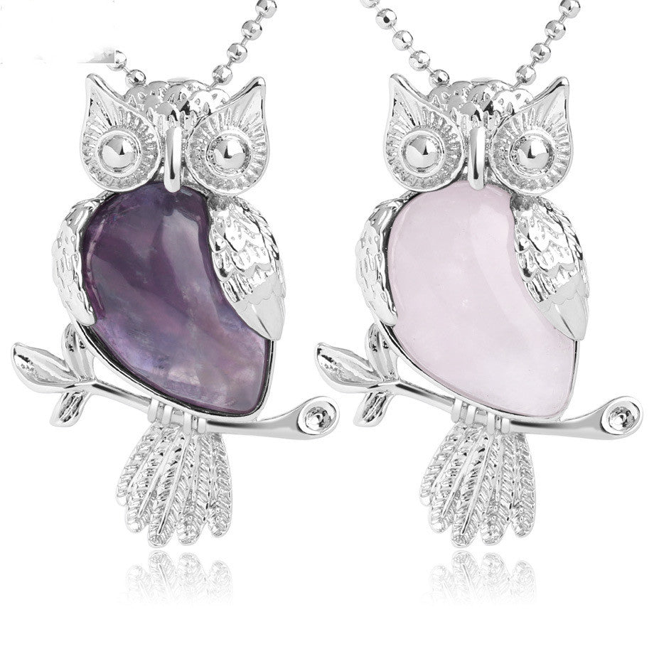 Two owl-shaped necklaces with purple and pink stones on a white background