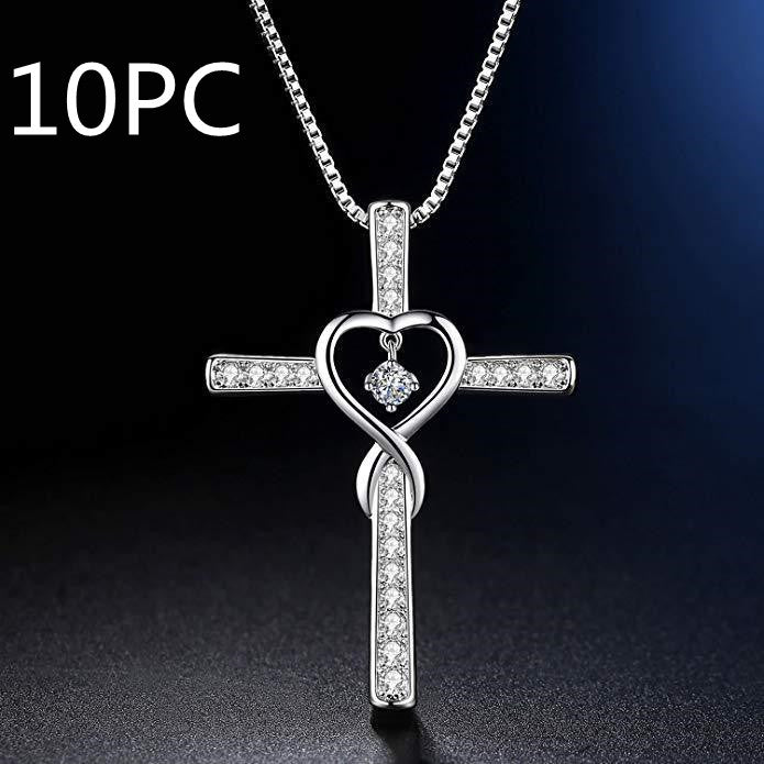 Silver cross pendant with heart design on a dark background