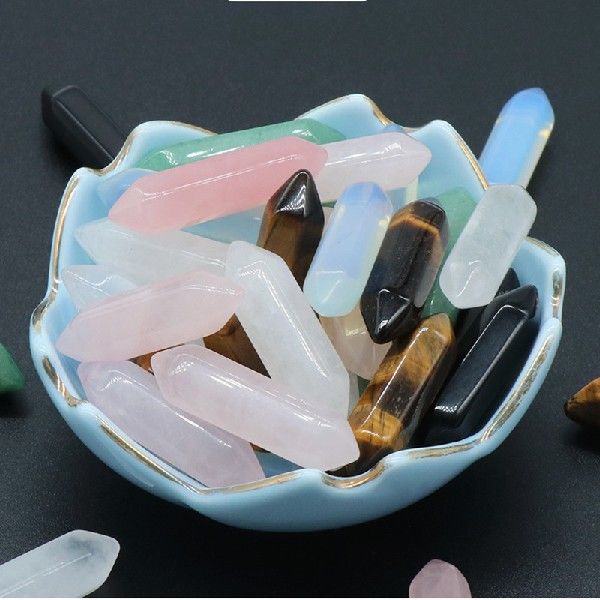 Colorful crystal points in a decorative bowl on a dark surface
