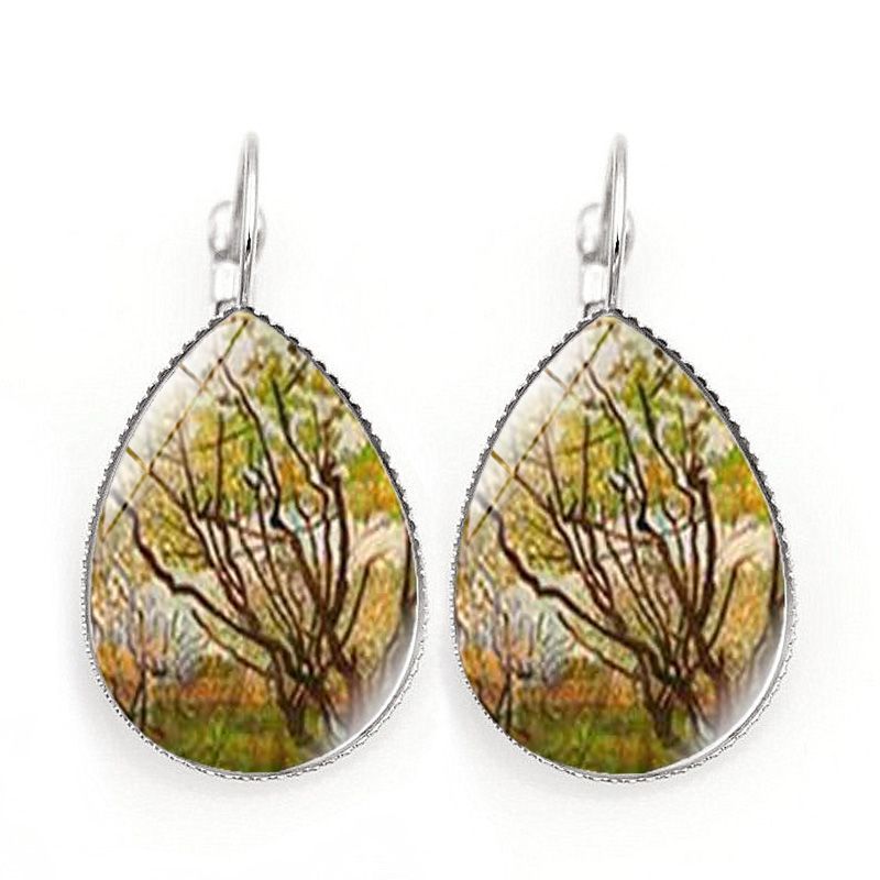 Teardrop-shaped earrings with nature-themed design on a white background